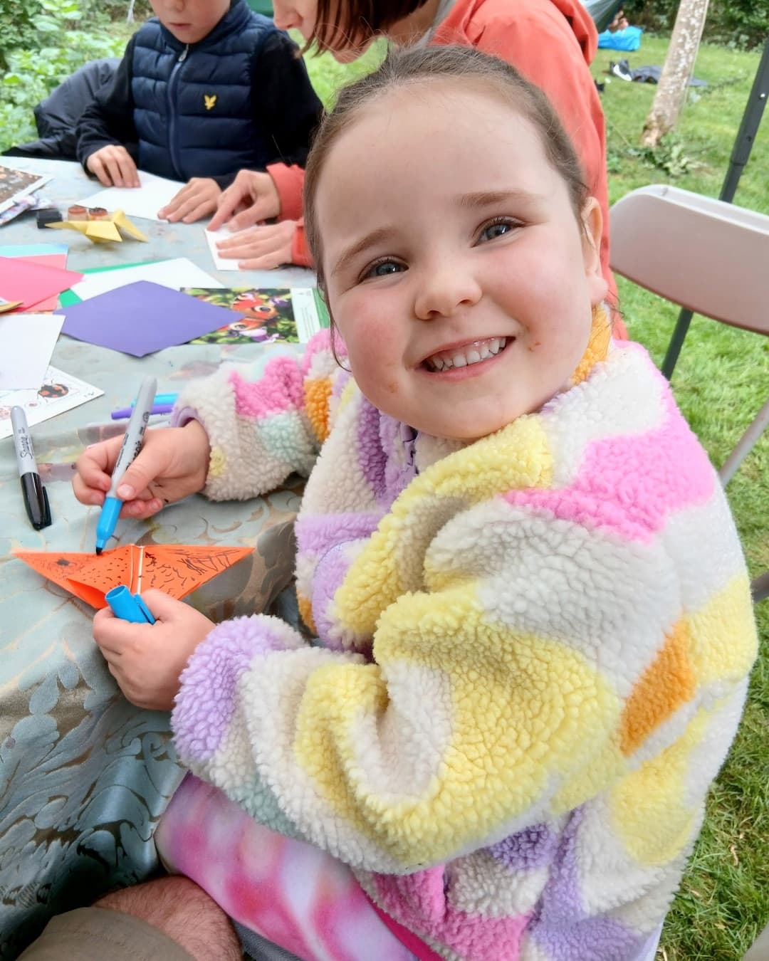 Child smiling during a nature craft workshop