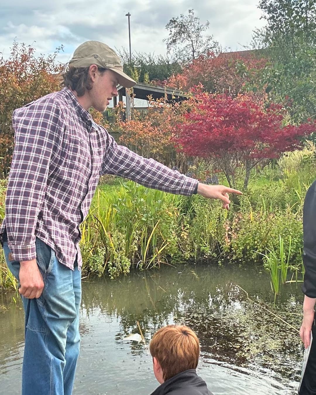 Community learning session beside a pond habitat